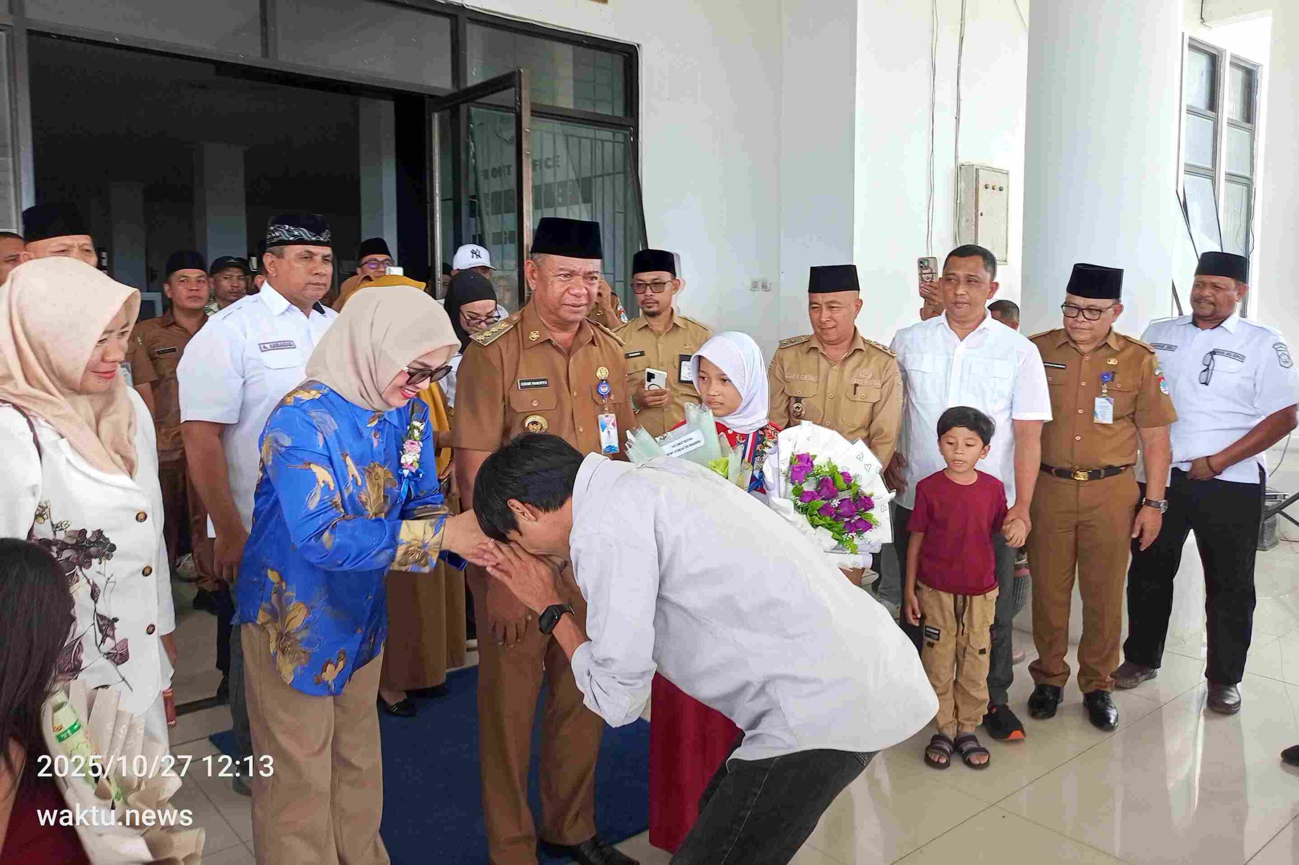 Mentor robotik Marfandri Lamatenggo bersalaman dengan Ketua TP-PKK Boltim Rosita Pobela yang mendampingi Dewi Athena