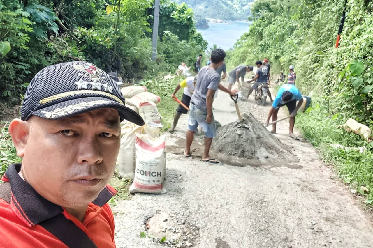 Camat Nuangan Mursit Mamonto bersama Warga Jiko Belangga gotong royong pengecoran jalan rusak di Kecamatan Nuangan, Boltim