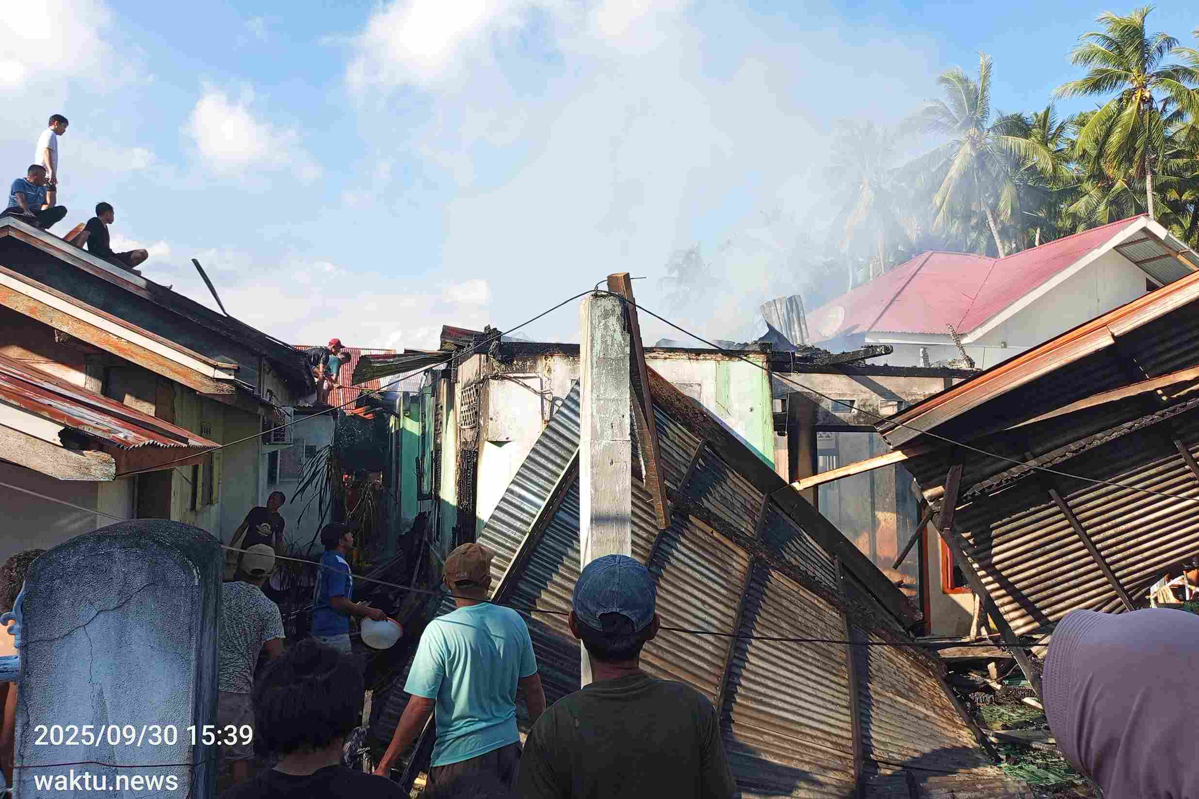 Rumah kos di Tutuyan Boltim ludes terbakar, warga berusaha padamkan api dengan peralatan seadanya.