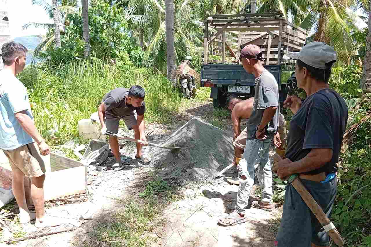 warga Loyow mengaduk semen dan pasir untuk pengecoran jalan kebun