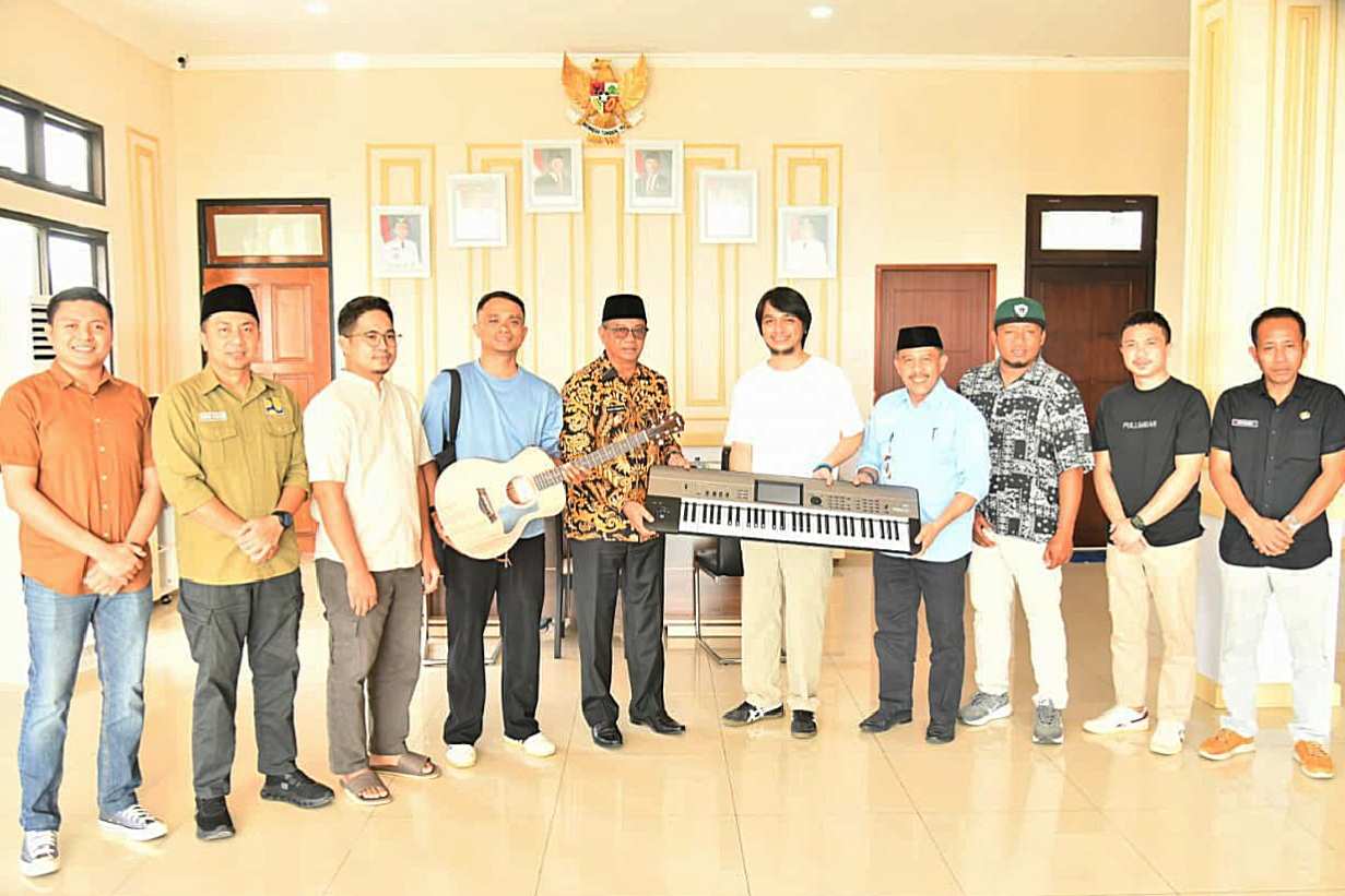 Bupati Boltim Oskar Manoppo menyerahkan alat musik kepada Braga Mongondow