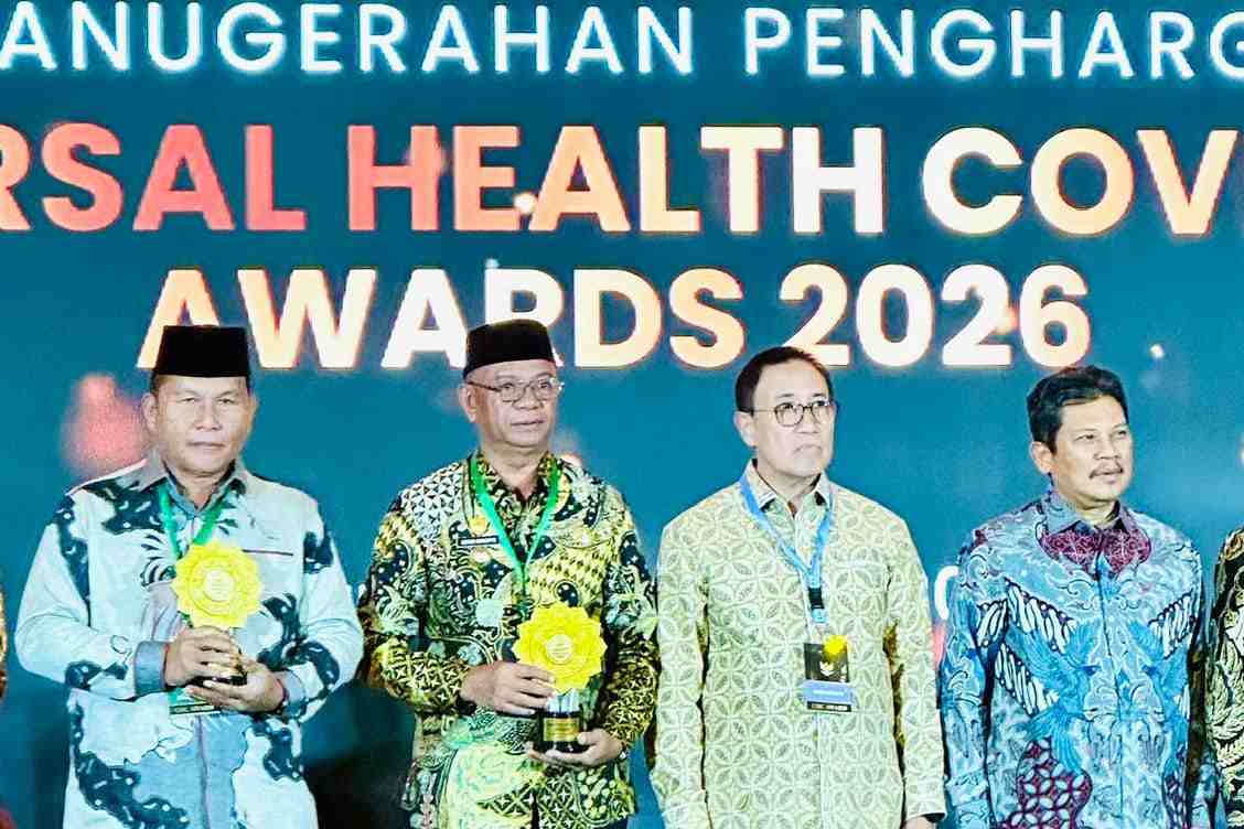 Bupati Boltim Oskar Manoppo saat menerima UHC Awards 2026