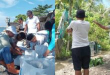 Bupati Boltim Oskar Manoppo bersama warga Paret Timur membuat tanggul darurat tahan abrasi pantai